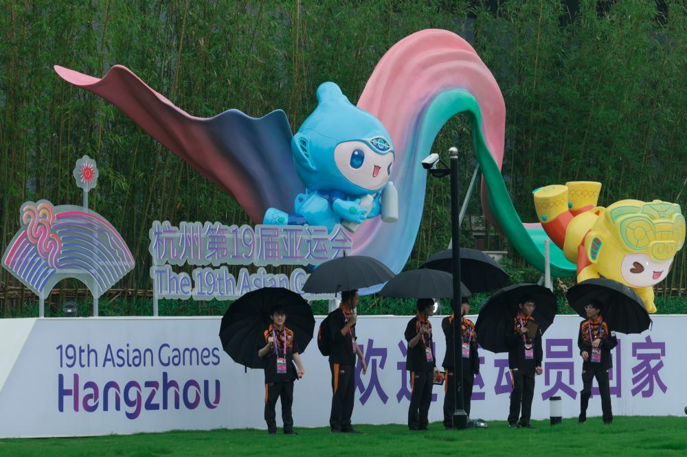HANGZHOU, Sept 22 -- Athletes holding an umbrella infront of the 19th Asian Games Hangzhou Mascot at the Athlete Village today. BERNAMAPIX