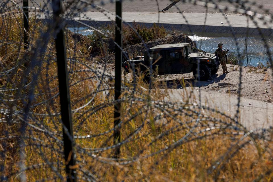 A member of the Texas National Guard stands by a vehicle along the Rio Bravo river, the border between Mexico and the US, as seen from El Paso, Texas, US, December 22, 2022. REUTERSPIX