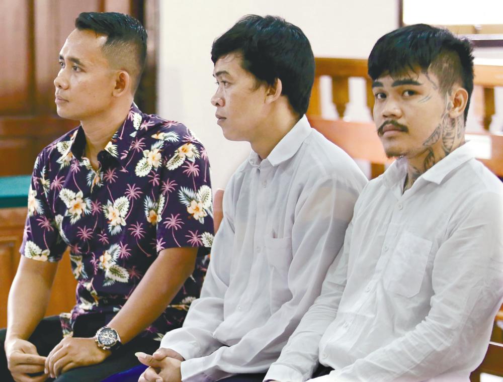 Cross-border crime ... Thai nationals Prakob Seetasang (2nd from left) and Adison Phonlamat (right), accused of drug smuggling, attend their trial at the Denpasar court in Bali on Wednesday. Indonesian judges sentenced the Thai duo to 16 years imprisonment for attempting to smuggle 1kg of methamphetamines into the resort island after swallowing plastic packages containing the drug. – AFPpix