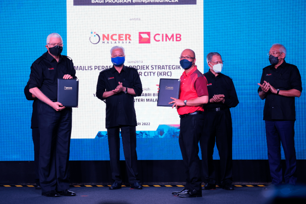 Jebasingam Issace John (left) and Abdul Rahman (third left) exchanging the MoA for the NCIA–CIMB Entrepreneur Scheme, witnessed by Ismail Sabri (second from left). Also present were Mustapa (second from right) and Mahdzir bin Khalid.