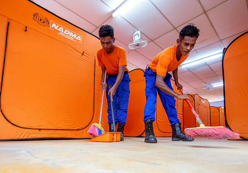 Members of the Civil Defence Force prepare the temporary shelter for the Orang Asli settlers in Gua Musang, on June 15, 2019. — Bernama