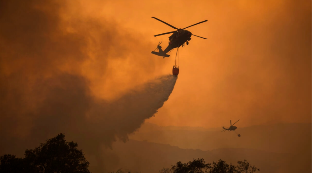 National Guard helicopters fight a wildfire in California; the rising number of such fires in the United States is increasing demands on troops. AFPPIX