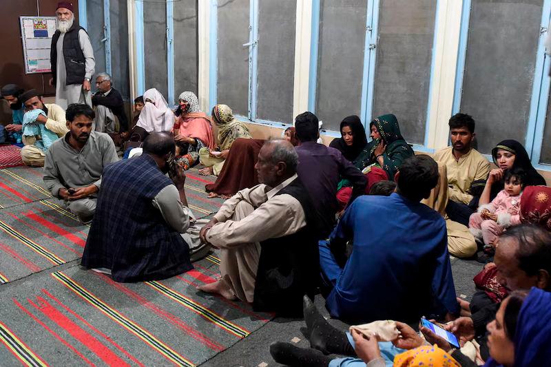 Passengers, who were rescued from a train after it was attacked by separatist militants, sit at the Mach Railway Station in Mach, Balochistan - REUTERSpix