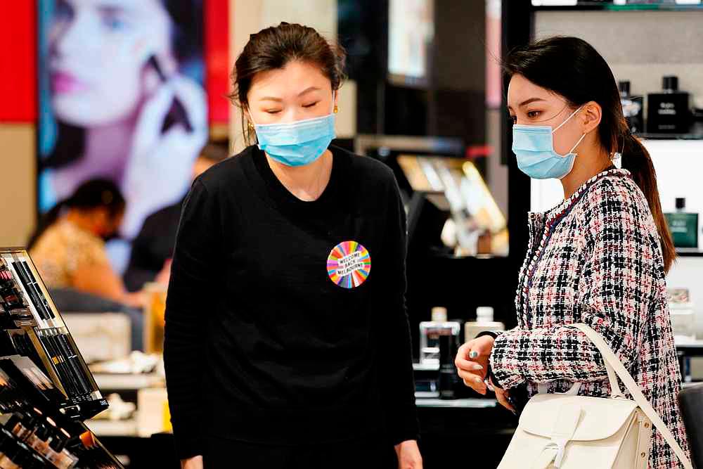 A shopper wearing a face mask is assisted in a retail store after Covid-19 restrictions were eased for the state of Victoria, in Melbourne, Australia October 28, 2020. — Reuters