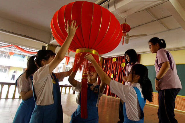 Students hang up a Chinese New Year lantern decoration at SMK Pusat Bandar Puchong 1 yesterday. — Bernama