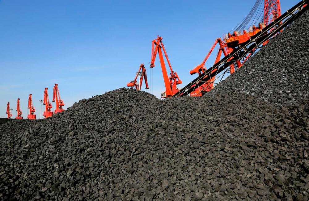 File picture of cranes unloading coal from a cargo ship at a port in Lianyungang, Jiangsu province, China. Coal miners are bearing the brunt of the sustainable investing trend – REUTERSPIX
