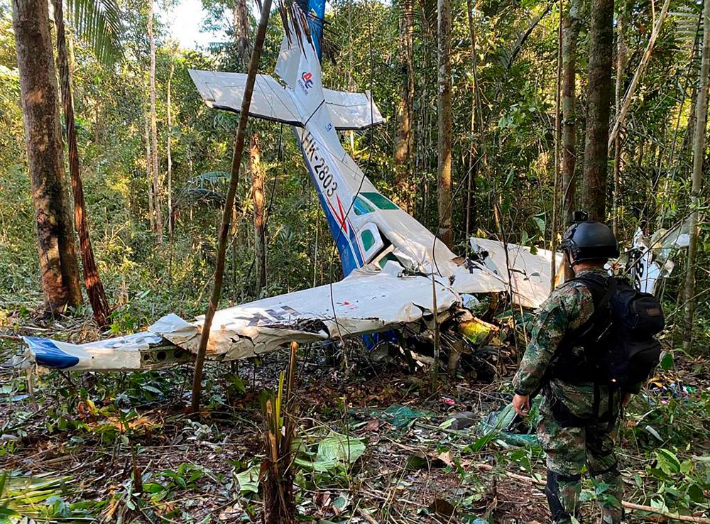 Handout picture released by the Colombian Army showing a soldier standing next to the wreckage of an aircraft that crashed in the Colombian Amazon forest in the municipality of Solano, department of Caqueta, on May 19, 2023. AFPPIX