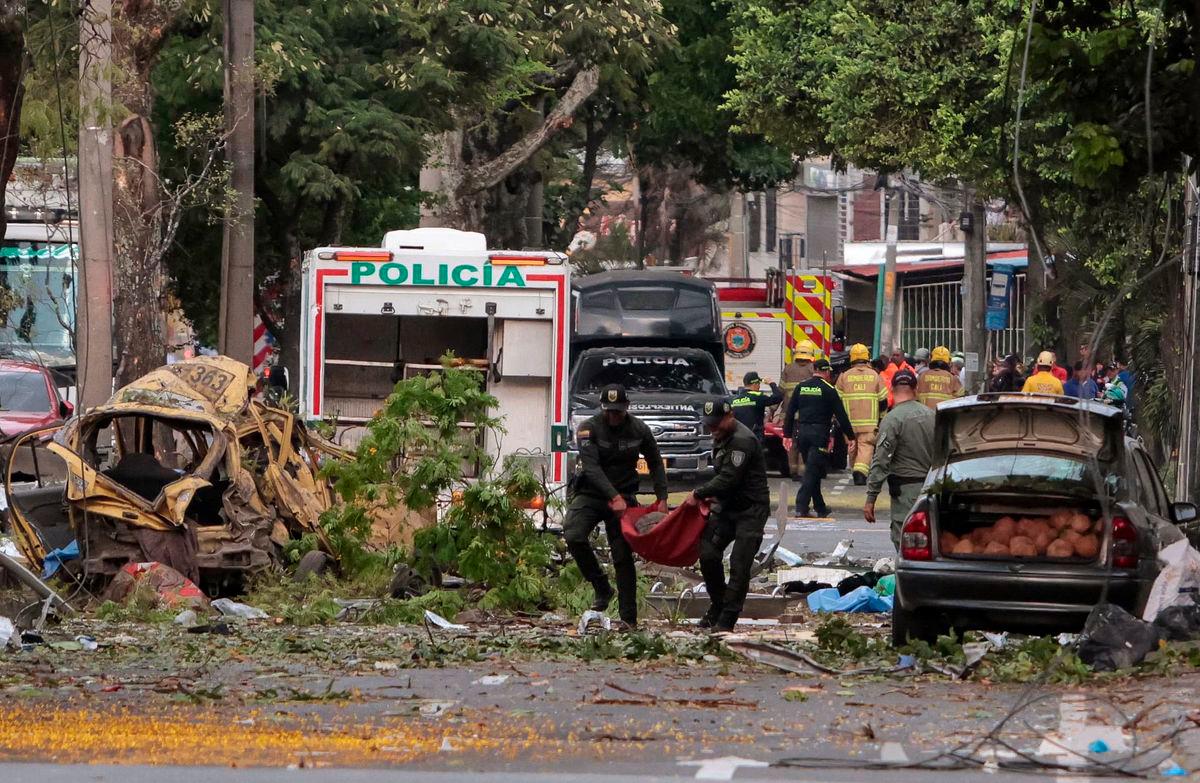 Police officers carry debris from the site of a bomb explosion in cali, Colombia on August 21 2025. Five people were killed and dozens were injured when a vehicle bomb targeted a military base on a busy street in the Colombian city of Cali on August 21, 2025, local authorities said. (Photo by Iusef Samir Rojas / AFP)