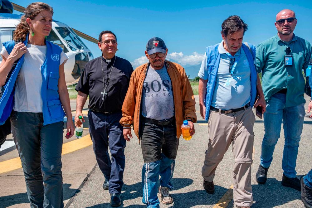 This handout picture released by the United Nations Verification Mission in Colombia shows Luis Manuel Diaz (C), father of Liverpool's forward Luis Diaz, walking accompanied by members of the mission after getting off a helicopter following his liberation at the Alfonso Lopez airport in Valledupar, Colombia, on November 9, 2023. - AFPPIX