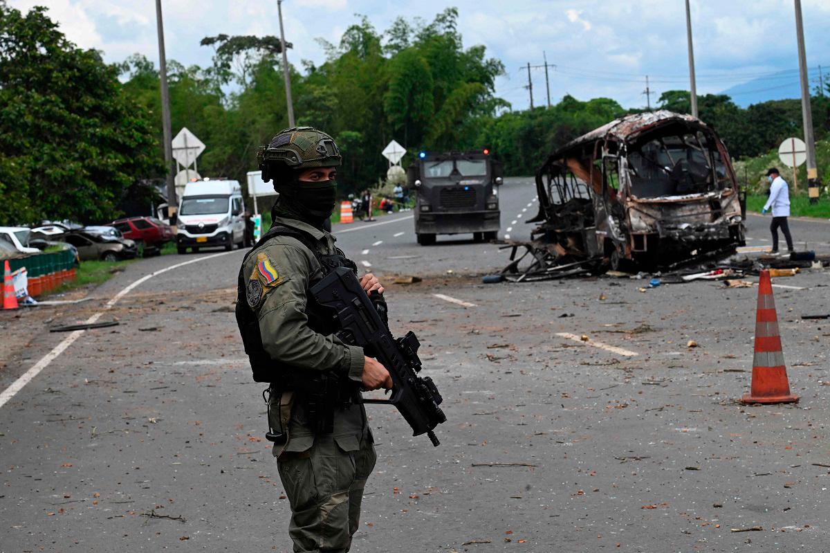 A police officer stands guard at the site where a bus exploded in front of a police station in Villa Rica, Cauca department, Colombia, on June 10, 2025. Southwest Colombia was rocked by a string of explosions and gun attacks that left at least three people dead Tuesday, police said, in what appeared to be a coordinated attack designed to sow terror. The attacks hit Cali -- the country’s third largest city -- and several nearby towns, targeting police stations and other municipal buildings. - Joaquin Sarmiento / AFP