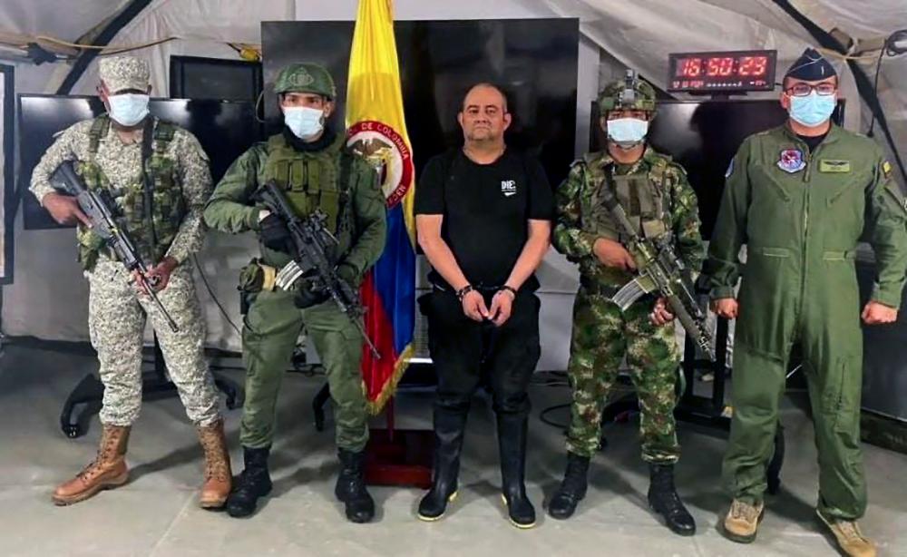 Handout picture released on October 23, 2021 by the Colombian Army press office showing members of the Colombian Army escorting Colombia’s most-wanted drug lord and head of the Gulf Clan, Dairo Antonio Usuga (C) -alias ‘Otoniel’-, after his capture in Bogota. AFPpix