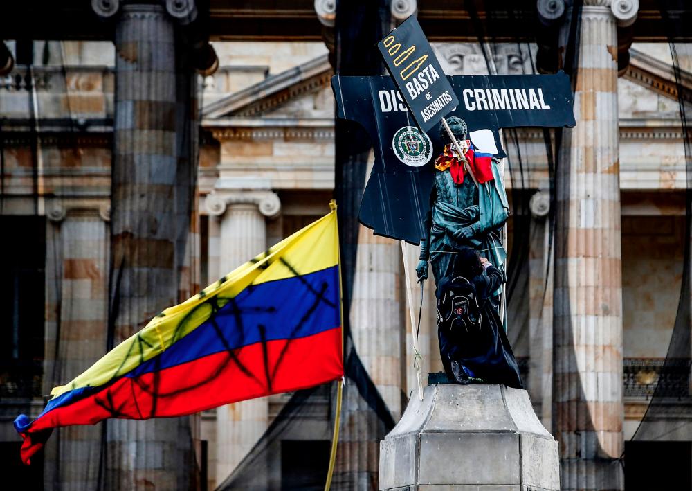 View of the statue of Liberator Simon Bolívar with allusive signs during a protest against police brutality, at Bolivar square in Bogota on Sept 21, 2020. — AFP