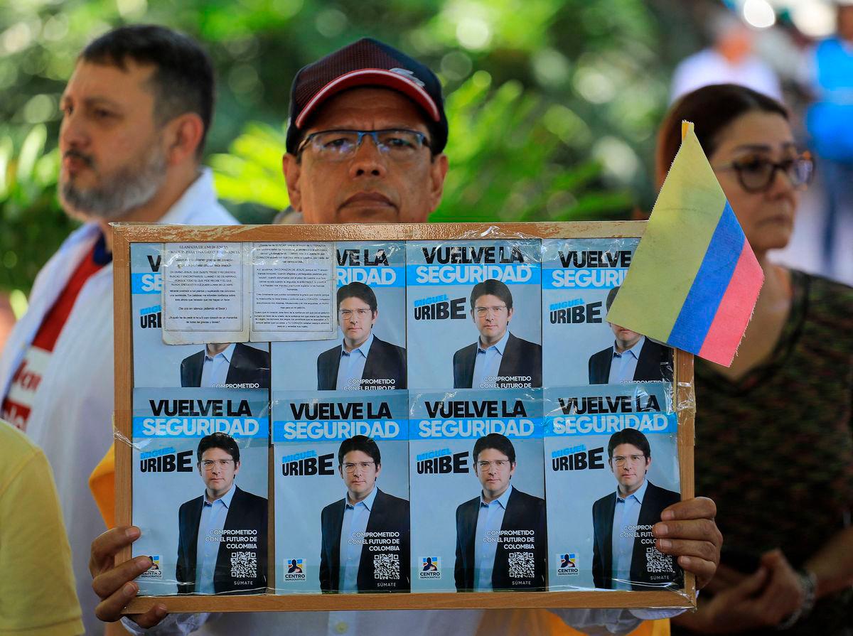 A man holds a sign with propaganda for presidential candidate Miguel Uribe during a protest against violence and in favor of peace in Medellin, Colombia, on June 8, 2025, the day after the attack on Uribe. AFPpix