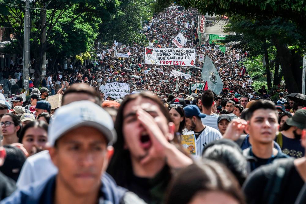 People march during a nationwide strike called by students, unions and indigenous groups to protest against the government of Colombia's President Ivan Duque in Medellin, Colombia, on Nov 21.— AFP