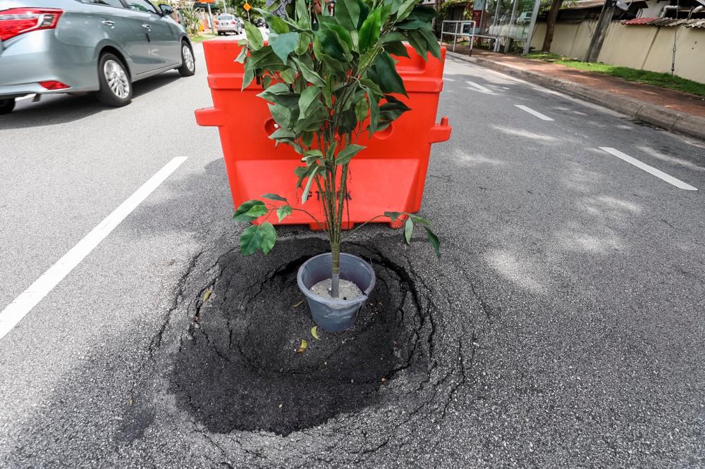 Many road users have suffered vehicle damage, bodily injuries, and some have even lost their lives due to long-unrepaired potholes and road iron covers that sit lower than the road surface. – THESUN