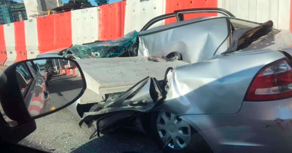 A one-sq metre concrete slab from a construction site of SUKE fell on a Proton Saga BLM driven by a woman at the Middle Ring Road 2 at 5.45pm yesterday. — Pix by Bernama via Twitter