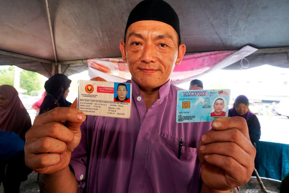 Abdul Rahman Abdullah, shows his card for the proof of conversion (L) and his IC, during an event at Menara Zakat, in Alor Star, on Sept 11, 2019. — Bernama