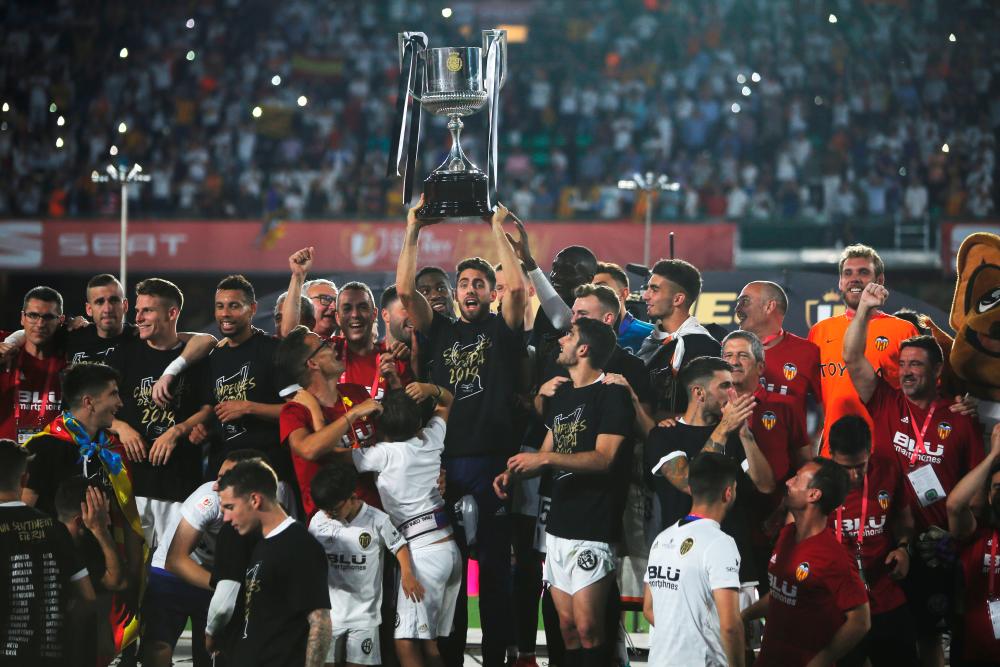 Valencia players celebrate winning the Copa del Rey final with the trophy. - Reuters