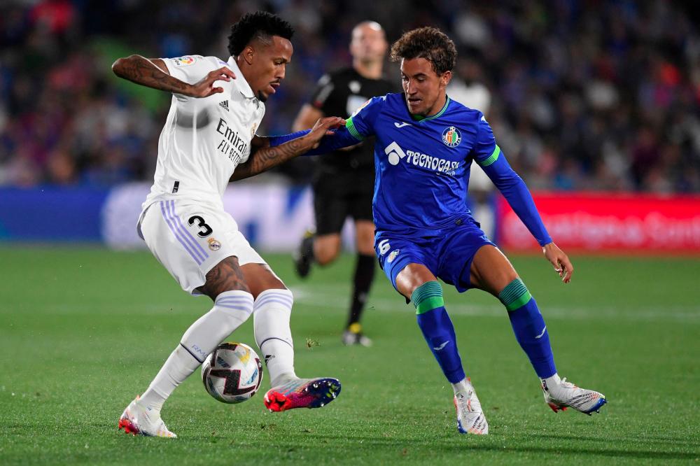 Real Madrid's Brazilian defender Eder Militao (L) vies with Getafe's Spanish midfielder Luis Milla during the Spanish League football match between Getafe CF and Real Madrid CF at the Coliseo Alfonso Perez stadium in Getafe on October 8, 2022. - AFPPIX