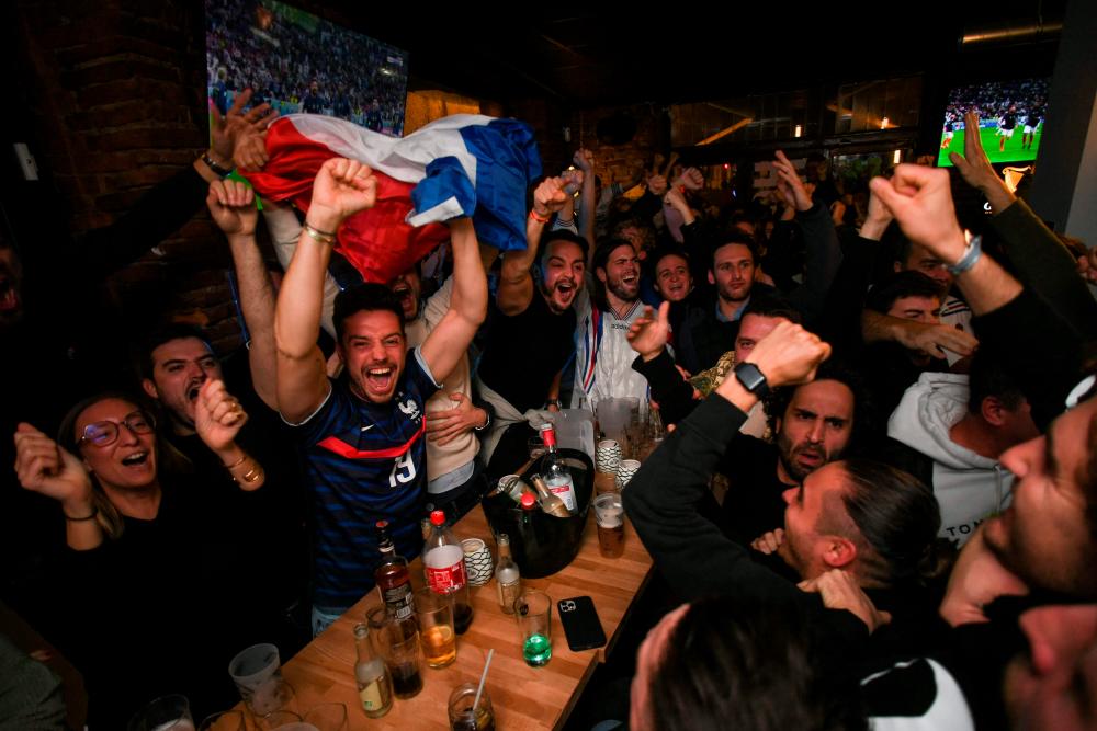 French supporters while watching the broadcast of the Qatar 2022 World Cup football match between France and England in a bar in Toulouse, south-western France, on December 10, 2022. AFPPIX