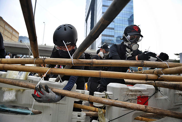 Protesters build barriers as they block a road in Hong Kong’s Kowloon Bay on Aug 24. — AFP