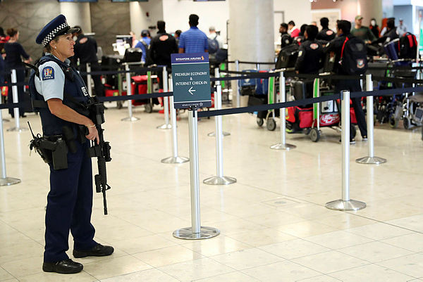 Armed police watch on as members of the Bangladesh cricket team check into Christchurch Airport as they look leave on March 16, 2019, following the deadly massacre on two mosques in the city. — AFP