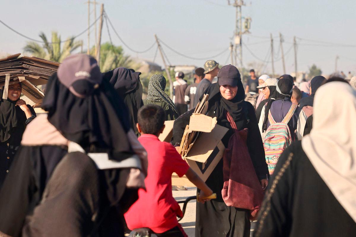 Palestinians make their way in the Mawasi area of Rafah on July 24, 2025, after receiving humanitarian aid from an aid distribution point in the southern Gaza Strip. (Photo by AFP)