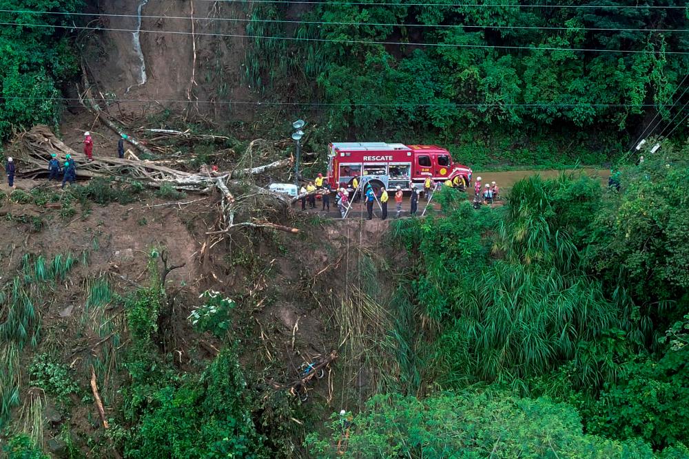 This handout image made available by Costa Rica's Fire Department press office shows the site where a bus and two other vehicles were pushed off a cliff by a landslide caused by heavy rains, in Cambroner, Alajuela Province, 80km west of San Jose/AFPPix