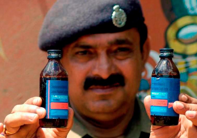 REPRESENTATIVE IMAGE: A police officer displays seized cough syrup bottles at a police station near the Bangladesh border in Amtali area of Tripura July 25, 2008. REUTERSPIX