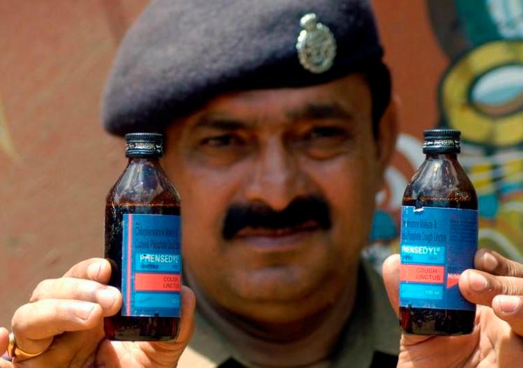 REPRESENTATIVE IMAGE: A police officer displays seized cough syrup bottles at a police station near the Bangladesh border in Amtali area of Tripura July 25, 2008. REUTERSPIX