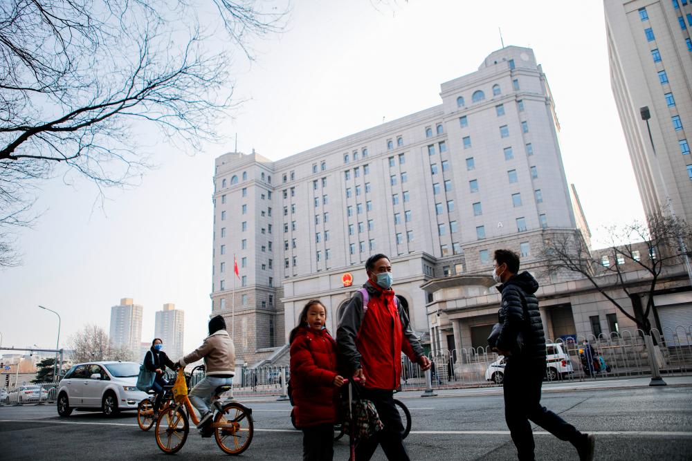 People walk outside the Beijing No. 2 Intermediate People's Court, where Australian journalist Cheng Lei is expected to face trial on state secrets charges, in Beijing, China March 31, 2022. REUTERSpix