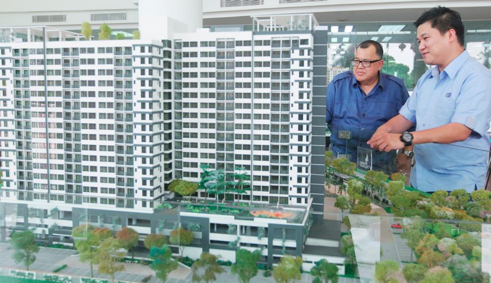 Yong (right) with a scale model of one of Crest Builder’s projects. - Zulkifli Ersal/THE SUN