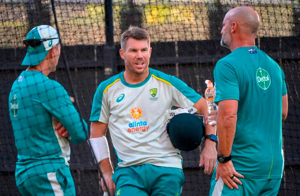 Australia’s batsman David Warner (C) talks to coaches about his injury during the practice session at Adelaide Oval on December 14, 2021, ahead of the second Ashes cricket Test match against England in Adelaide. AFPpix