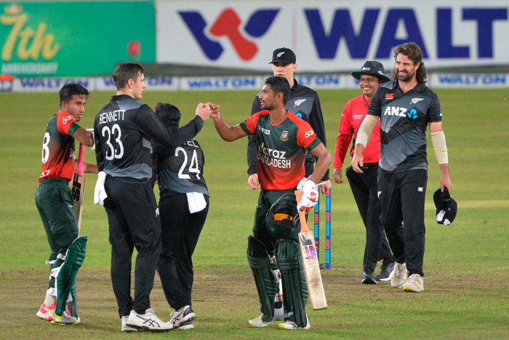 Mahmudullah (centre) and Bennett (2nd left) greet after Bangladesh’s victory at the end of the fourth Twenty20 international match at the Sher-e-Bangla National Cricket Stadium in Dhaka. – AFPPIX