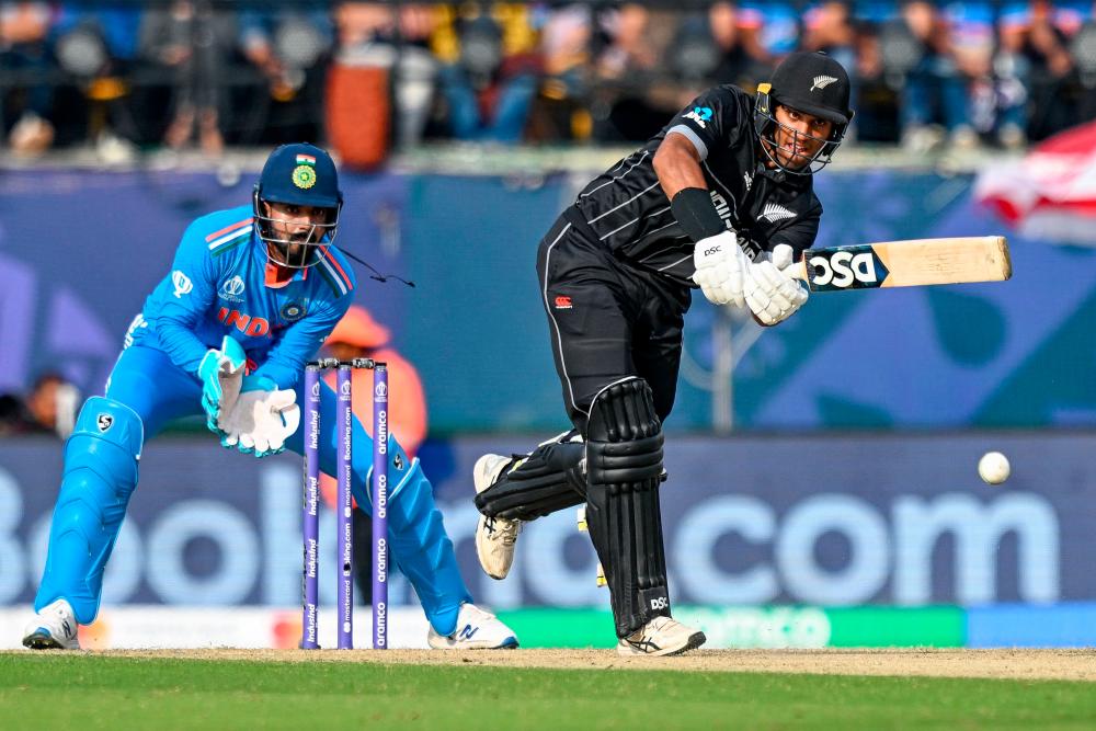 New Zealand's Rachin Ravindra (R) plays a shot during the 2023 ICC Men's Cricket World Cup one-day international (ODI) match between India and New Zealand at the Himachal Pradesh Cricket Association Stadium in Dharamsala on October 22, 2023. AFPPIX