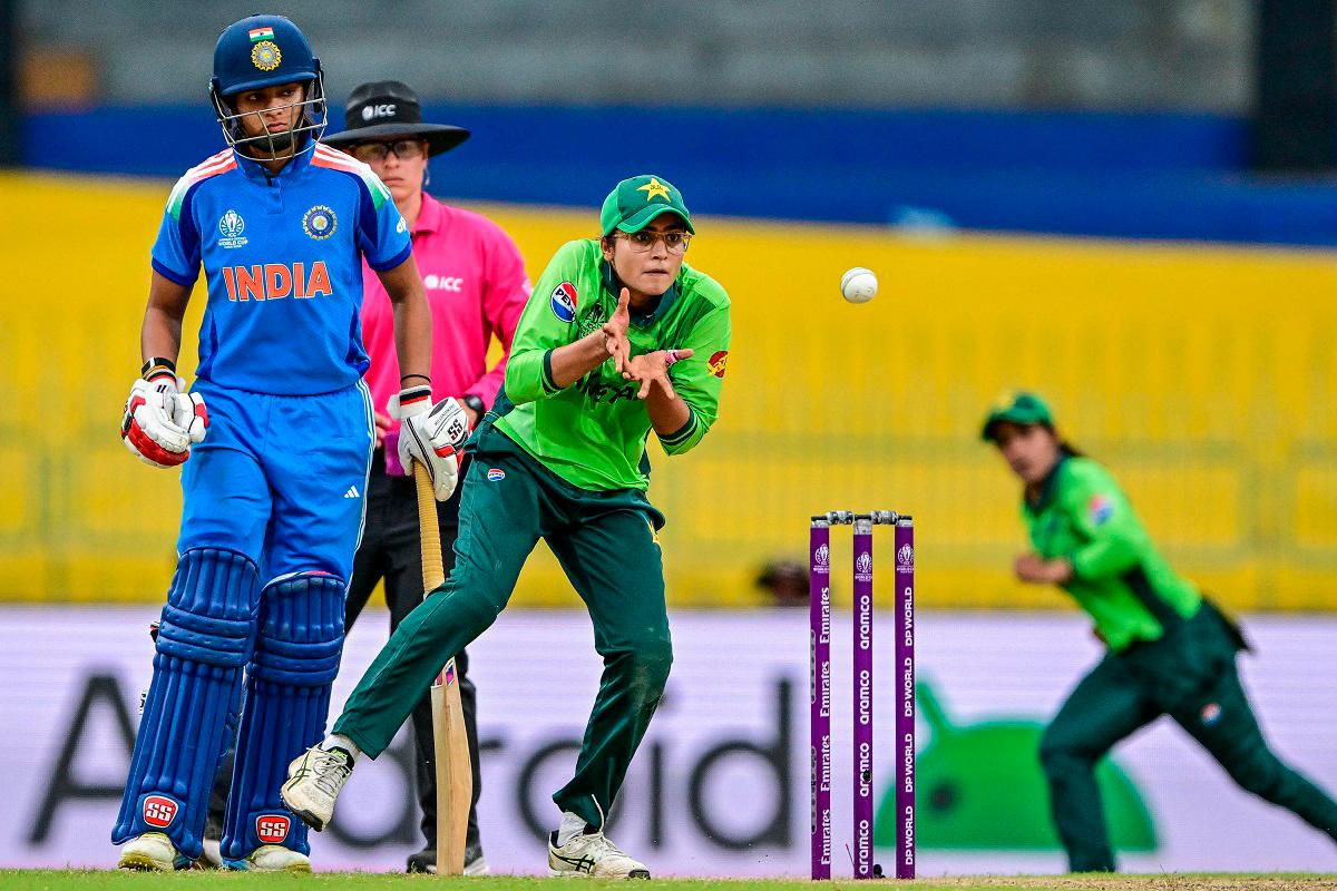 Pakistan’s Rameen Shamim (R) collects the ball as India’s Pratika Rawal watches during the ICC Women’s Cricket World Cup 2025. - S. KODIKARA / AFP