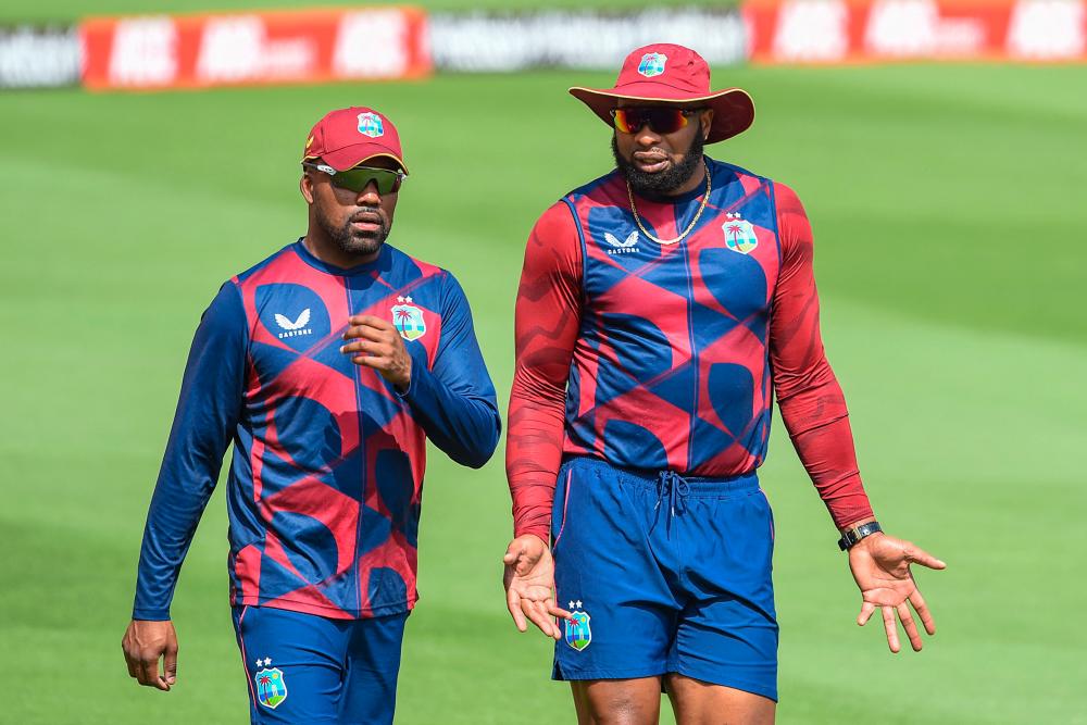 West Indies’ captain Kieron Pollard (R) speaks with teammate Darren Bravo during a training session at the Narendra Modi Stadium in Motera on February 8, 2022, on the eve of the second one day international (ODI) cricket match against India. AFPPIX