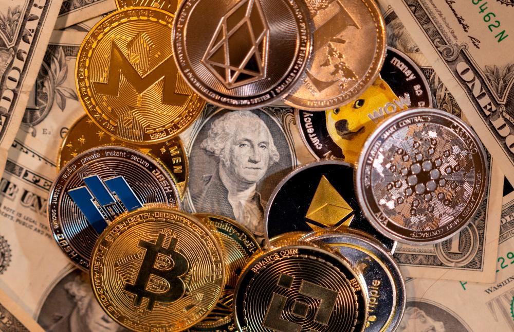 Representations of virtual cryptocurrencies are placed on US dollar banknotes in this illustration. – Reuterspic