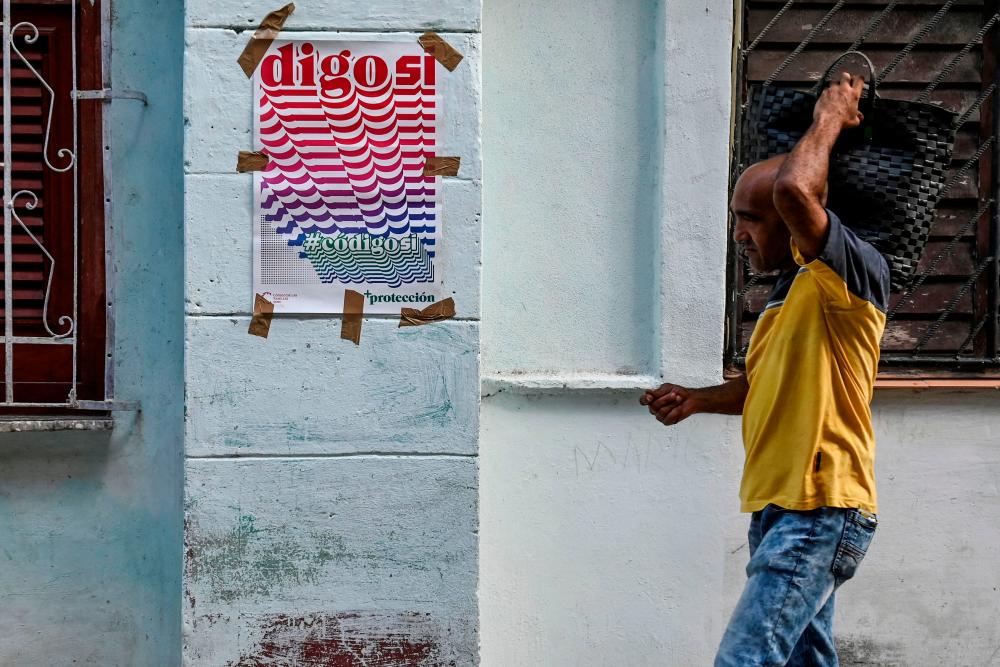 A man walks past a sign in favor of the new Family Code referendum in Havana on September 21, 2022. On September 25, Cuba will submit to referendum a new Family Code that, among other changes, will legalize same-sex marriage. AFPPIX