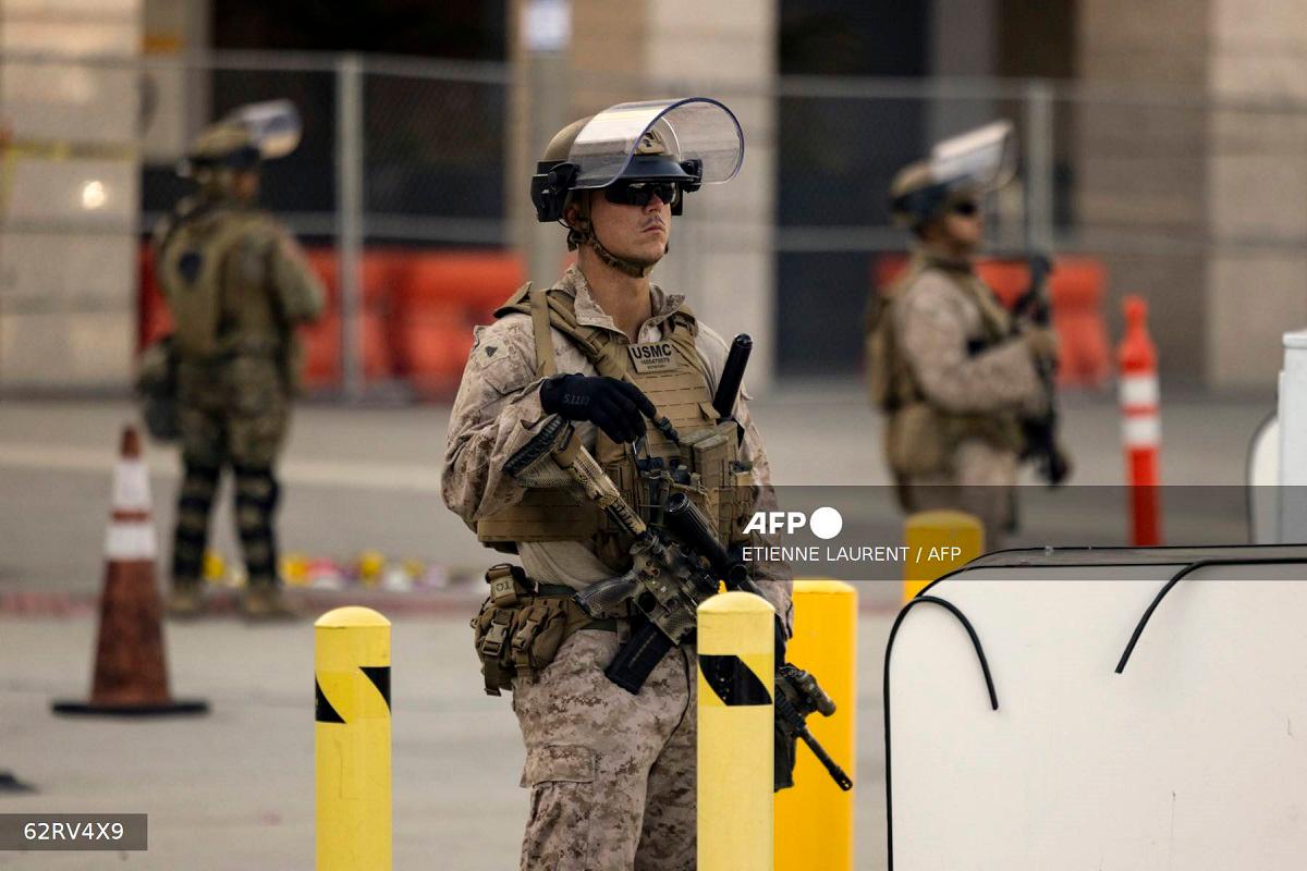 US Marines stand guard as about ten protesters demonstrate outside the Metropolitan Detention Center following protests sparked by federal immigration operations in Los Angeles on June 14, 2025. - ETIENNE LAURENT / AFP