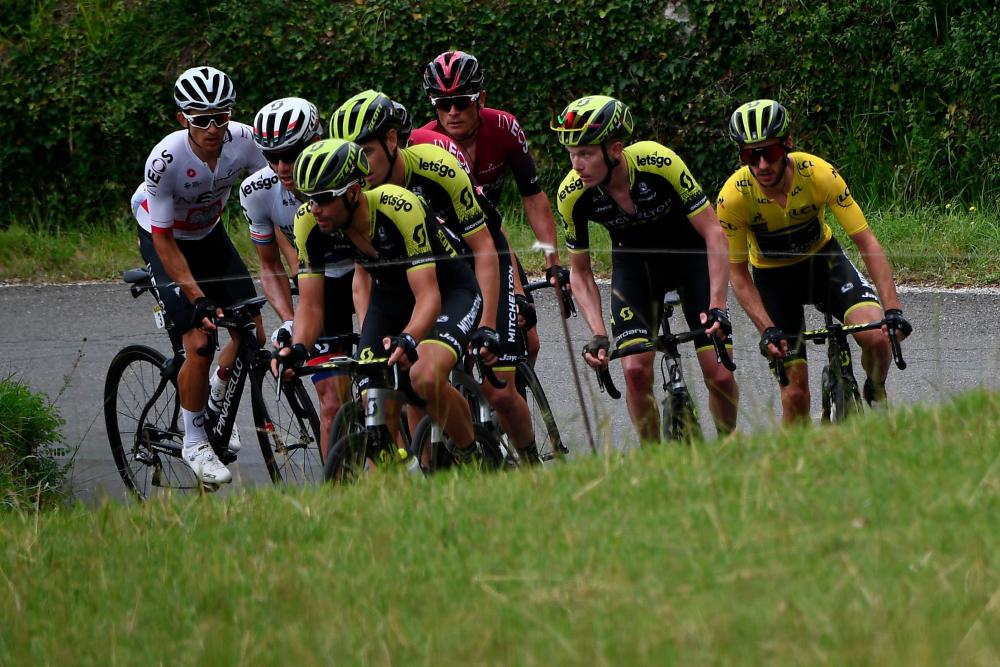 Team Mitchelton-Scott rider Great Britain's Adam Yates (R), wearing the overall leader's yellow jersey, rides with teammates and other cyclists during the seventh stage of the 71st edition of the Criterium du Dauphine cycling race, 133,5km between Saint-Genix-les-Villages and Les Sept Laux-Pipay on June 15, 2019. — AFP