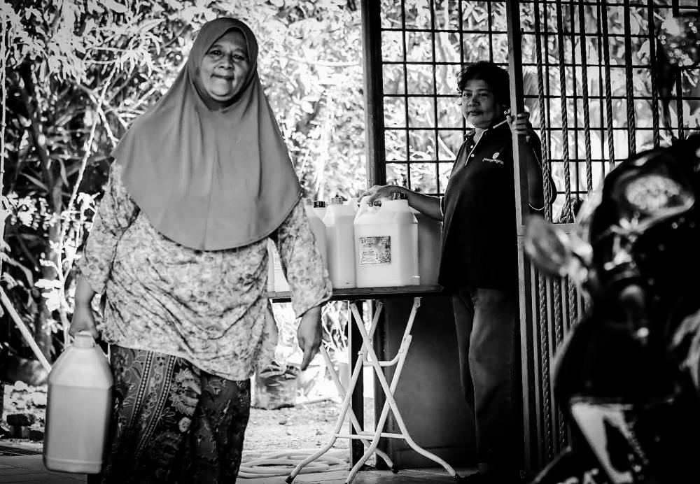 $!A lady in her 50s bought detergent sold by Azizah at her house. Azizah looks while her customer goes.