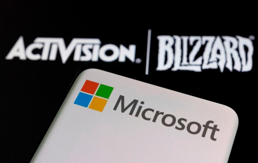 Microsoft logo is seen on a smartphone placed on displayed Activision Blizzard logo in this illustration taken January 18, 2022. REUTERSpix