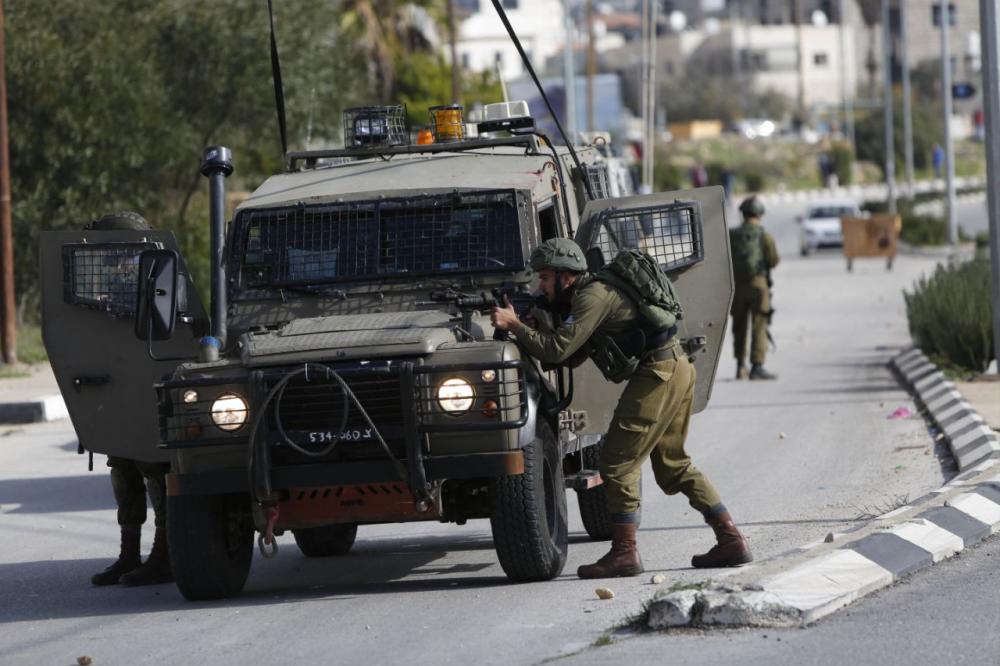 Israeli soldiers conduct a search for suspects of a shooting attack yesterday in the West Bank City of Ramallah, Monday, on Dec. 10, 2018. — AFP