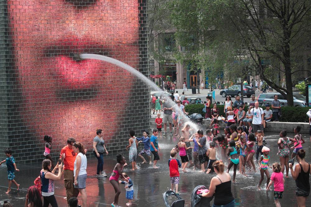 People cool off downtown in Crown Fountain as temperatures climb into the 90's with a heat index expected to reach as high as 115 degrees on July 19, 2019 in Chicago, Illinois. - AFP