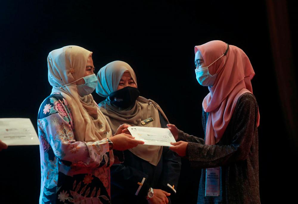 Minister of Higher Education Datuk Dr Noraini Ahmad (left) handed over a contribution to one of the selected student during UiTM Perihatin Program . Asyraf Rasid / theSun