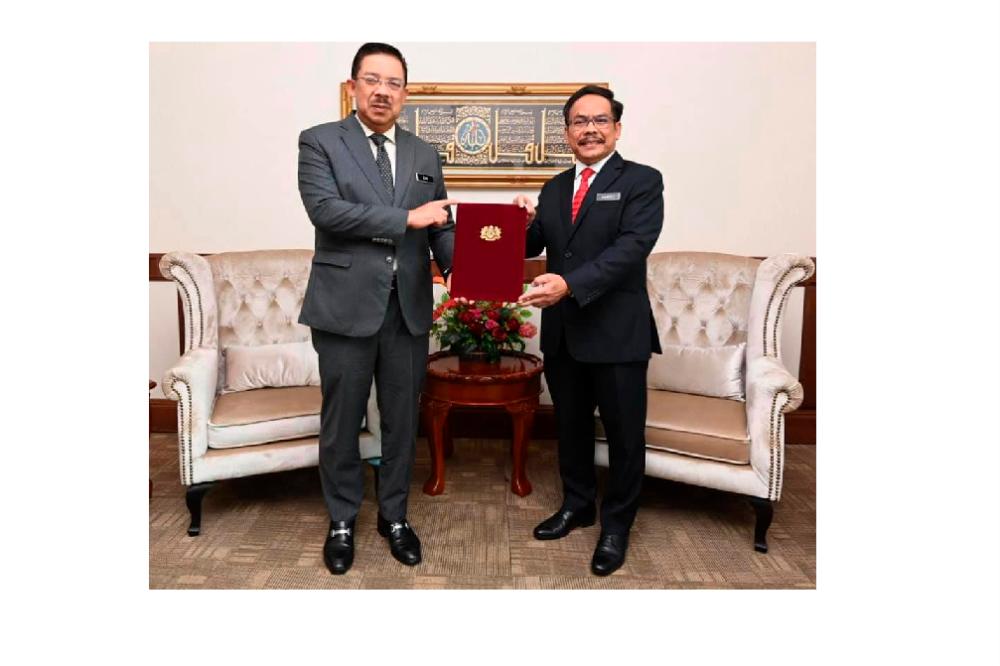 Chief Secretary to the Government Datuk Seri Mohd Zuki Ali (L) presents the letter of appointment to the next Public Works Department (JKR) director-general Datuk Mohamad Zulkefly Sulaiman, on July 23, 2020. — Facebook pix courtesy of Datuk Seri Mohd Zuki Ali, Ketua Setiausaha Negara