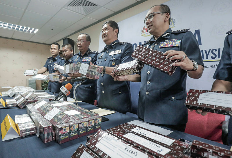 Central Zone Customs assistant director-general Datuk Zulkurnain Mohamed and his fellow officers hold the contraband cigarettes worth RM6.82 million seized, in KLIA since last month. — Sunpix by Ashraf Shamsul