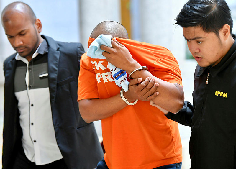 The accused (C) is led out of the magistrate’s court in Putrajaya, on May 20, 2019. — Bernama