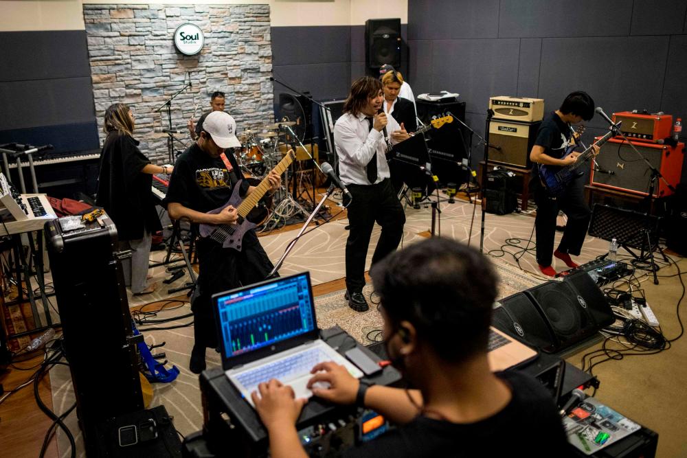In this photo taken on February 4, 2022, Thai metal band Defying Decay rehearse at Soul Studios in Bangkok. The group's latest single The Law 112: Secrecy and Renegades is a raucous, defiant anthem with a taboo-defying message -- challenging Thailand's draconian lese majeste laws. AFPPix